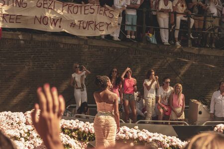Amsterdam, Netherlands - August 3, 2013: A vintage color tone picture  of Amsterdam gay parade in a canal on a sunny day with people having fun dancing on a boatのeditorial素材