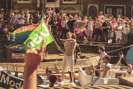 Amsterdam, Netherlands - August 3, 2013: A vintage color tone picture  of Amsterdam gay parade in a canal on a sunny day with people having fun dancing on a boatのeditorial素材