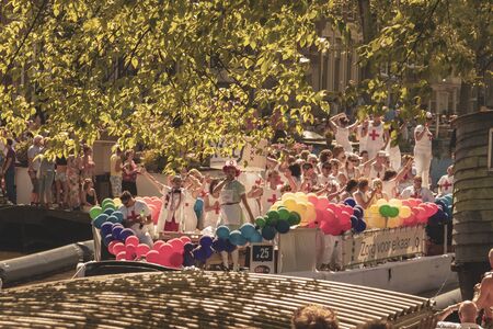 Amsterdam, Netherlands - August 3, 2013: A vintage color tone picture  of Amsterdam gay parade in a canal on a sunny day with people having fun dancing on a boatのeditorial素材