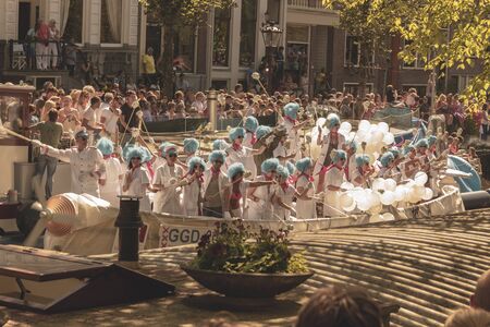 Amsterdam, Netherlands - August 3, 2013: A vintage color tone picture  of Amsterdam gay parade in a canal on a sunny day with people having fun dancing on a boatのeditorial素材