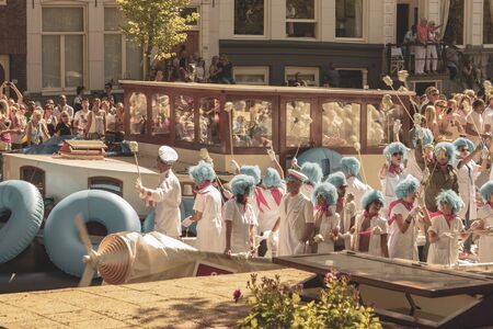 Amsterdam, Netherlands - August 3, 2013: A vintage color tone picture  of Amsterdam gay parade in a canal on a sunny day with people having fun dancing on a boatのeditorial素材