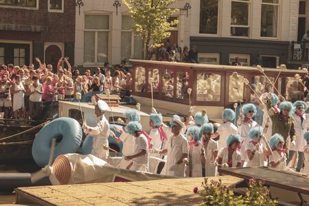 Amsterdam, Netherlands - August 3, 2013: A vintage color tone picture  of Amsterdam gay parade in a canal on a sunny day with people having fun dancing on a boatのeditorial素材