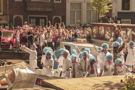 Amsterdam, Netherlands - August 3, 2013: A vintage color tone picture  of Amsterdam gay parade in a canal on a sunny day with people having fun dancing on a boatのeditorial素材