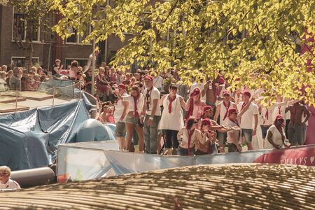 Amsterdam, Netherlands - August 3, 2013: A vintage color tone picture  of Amsterdam gay parade in a canal on a sunny day with people having fun dancing on a boatのeditorial素材