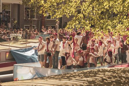 Amsterdam, Netherlands - August 3, 2013: A vintage color tone picture  of Amsterdam gay parade in a canal on a sunny day with people having fun dancing on a boatのeditorial素材