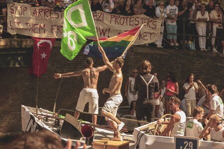 Amsterdam, Netherlands - August 3, 2013: A vintage color tone picture  of Amsterdam gay parade in a canal on a sunny day with people having fun dancing on a boatのeditorial素材