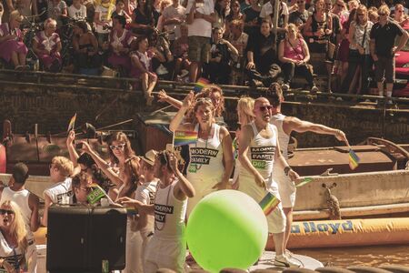 Amsterdam, Netherlands - August 3, 2013: A vintage color tone picture  of Amsterdam gay parade in a canal on a sunny day with people having fun dancing on a boatのeditorial素材