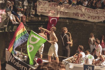 Amsterdam, Netherlands - August 3, 2013: A vintage color tone picture  of Amsterdam gay parade in a canal on a sunny day with people having fun dancing on a boatのeditorial素材