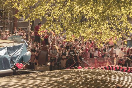 Amsterdam, Netherlands - August 3, 2013: A vintage color tone picture  of Amsterdam gay parade in a canal on a sunny day with people having fun dancing on a boatのeditorial素材