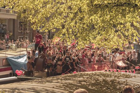 Amsterdam, Netherlands - August 3, 2013: A vintage color tone picture  of Amsterdam gay parade in a canal on a sunny day with people having fun dancing on a boatのeditorial素材
