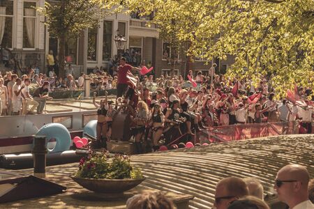 Amsterdam, Netherlands - August 3, 2013: A vintage color tone picture  of Amsterdam gay parade in a canal on a sunny day with people having fun dancing on a boatのeditorial素材