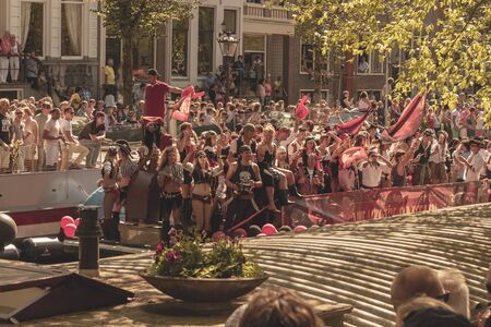 Amsterdam, Netherlands - August 3, 2013: A vintage color tone picture  of Amsterdam gay parade in a canal on a sunny day with people having fun dancing on a boatのeditorial素材