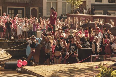 Amsterdam, Netherlands - August 3, 2013: A vintage color tone picture  of Amsterdam gay parade in a canal on a sunny day with people having fun dancing on a boatのeditorial素材