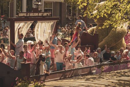 Amsterdam, Netherlands - August 3, 2013: A vintage color tone picture  of Amsterdam gay parade in a canal on a sunny day with people having fun dancing on a boatのeditorial素材