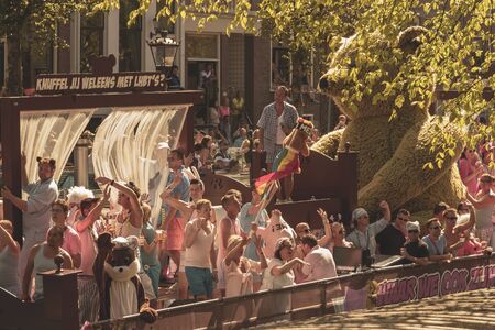 Amsterdam, Netherlands - August 3, 2013: A vintage color tone picture  of Amsterdam gay parade in a canal on a sunny day with people having fun dancing on a boatのeditorial素材