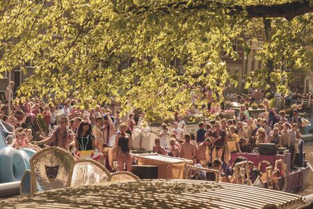 Amsterdam, Netherlands - August 3, 2013: A vintage color tone picture  of Amsterdam gay parade in a canal on a sunny day with people having fun dancing on a boatのeditorial素材