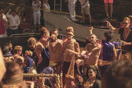 Amsterdam, Netherlands - August 3, 2013: A vintage color tone picture  of Amsterdam gay parade in a canal on a sunny day with people having fun dancing on a boatのeditorial素材