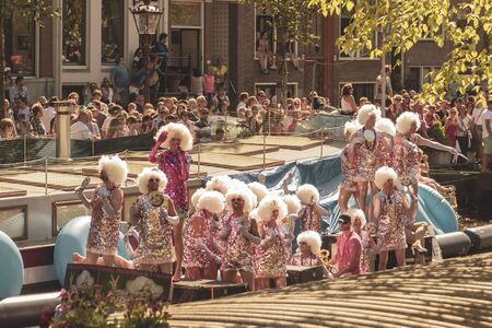 Amsterdam, Netherlands - August 3, 2013: A vintage color tone picture  of Amsterdam gay parade in a canal on a sunny day with people having fun dancing on a boatのeditorial素材