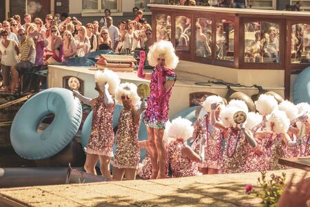 Amsterdam, Netherlands - August 3, 2013: A vintage color tone picture  of Amsterdam gay parade in a canal on a sunny day with people having fun dancing on a boatのeditorial素材