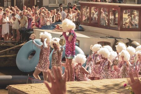 Amsterdam, Netherlands - August 3, 2013: A vintage color tone picture  of Amsterdam gay parade in a canal on a sunny day with people having fun dancing on a boatのeditorial素材