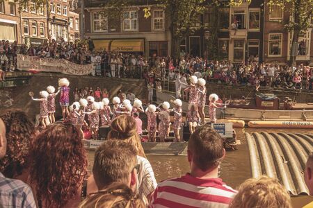 Amsterdam, Netherlands - August 3, 2013: A vintage color tone picture  of Amsterdam gay parade in a canal on a sunny day with people having fun dancing on a boatのeditorial素材
