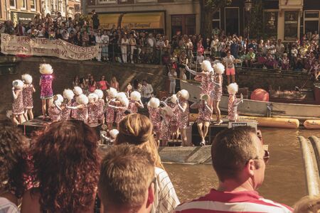 Amsterdam, Netherlands - August 3, 2013: A vintage color tone picture  of Amsterdam gay parade in a canal on a sunny day with people having fun dancing on a boatのeditorial素材