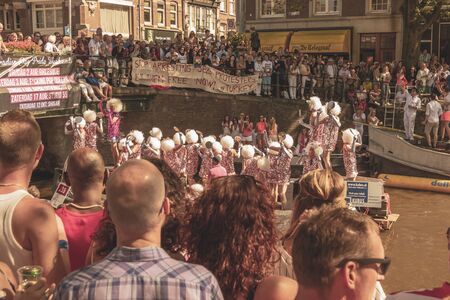 Amsterdam, Netherlands - August 3, 2013: A vintage color tone picture  of Amsterdam gay parade in a canal on a sunny day with people having fun dancing on a boatのeditorial素材