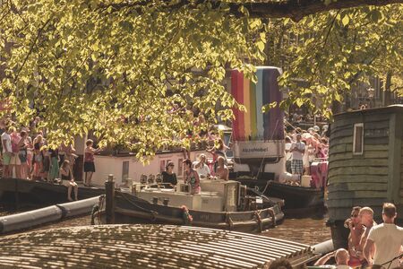 Amsterdam, Netherlands - August 3, 2013: A vintage color tone picture  of Amsterdam gay parade in a canal on a sunny day with people having fun dancing on a boatのeditorial素材