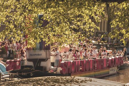 Amsterdam, Netherlands - August 3, 2013: A vintage color tone picture  of Amsterdam gay parade in a canal on a sunny day with people having fun dancing on a boatのeditorial素材
