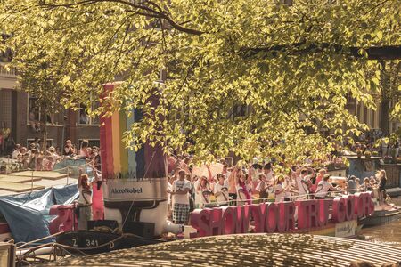 Amsterdam, Netherlands - August 3, 2013: A vintage color tone picture  of Amsterdam gay parade in a canal on a sunny day with people having fun dancing on a boatのeditorial素材