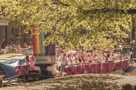 Amsterdam, Netherlands - August 3, 2013: A vintage color tone picture  of Amsterdam gay parade in a canal on a sunny day with people having fun dancing on a boatのeditorial素材