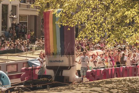 Amsterdam, Netherlands - August 3, 2013: A vintage color tone picture  of Amsterdam gay parade in a canal on a sunny day with people having fun dancing on a boatのeditorial素材