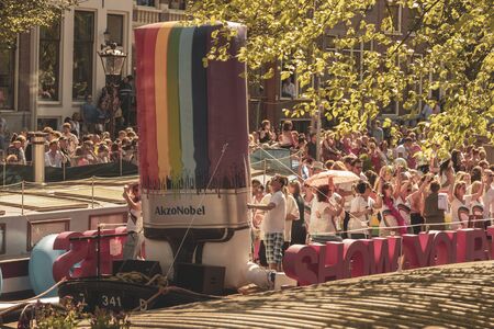 Amsterdam, Netherlands - August 3, 2013: A vintage color tone picture  of Amsterdam gay parade in a canal on a sunny day with people having fun dancing on a boatのeditorial素材