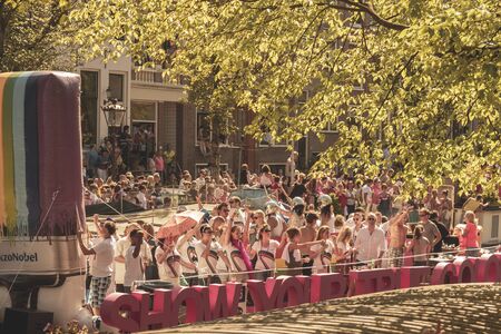 Amsterdam, Netherlands - August 3, 2013: A vintage color tone picture  of Amsterdam gay parade in a canal on a sunny day with people having fun dancing on a boatのeditorial素材