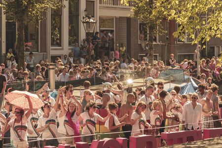 Amsterdam, Netherlands - August 3, 2013: A vintage color tone picture  of Amsterdam gay parade in a canal on a sunny day with people having fun dancing on a boatのeditorial素材