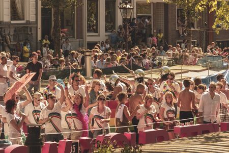 Amsterdam, Netherlands - August 3, 2013: A vintage color tone picture  of Amsterdam gay parade in a canal on a sunny day with people having fun dancing on a boatのeditorial素材