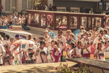 Amsterdam, Netherlands - August 3, 2013: A vintage color tone picture  of Amsterdam gay parade in a canal on a sunny day with people having fun dancing on a boatのeditorial素材