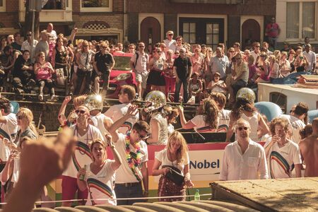 Amsterdam, Netherlands - August 3, 2013: A vintage color tone picture  of Amsterdam gay parade in a canal on a sunny day with people having fun dancing on a boatのeditorial素材