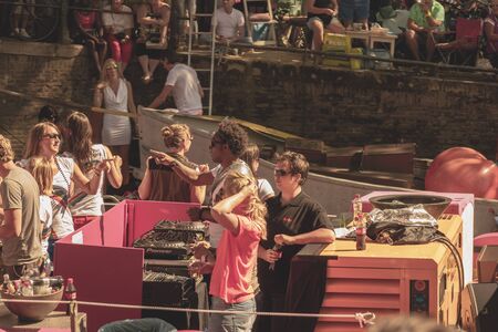 Amsterdam, Netherlands - August 3, 2013: A vintage color tone picture  of Amsterdam gay parade in a canal on a sunny day with people having fun dancing on a boatのeditorial素材