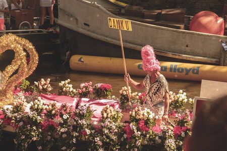 Amsterdam, Netherlands - August 3, 2013: A vintage color tone picture  of Amsterdam gay parade in a canal on a sunny day with people having fun dancing on a boatのeditorial素材