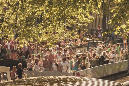 Amsterdam, Netherlands - August 3, 2013: A vintage color tone picture  of Amsterdam gay parade in a canal on a sunny day with people having fun dancing on a boatのeditorial素材