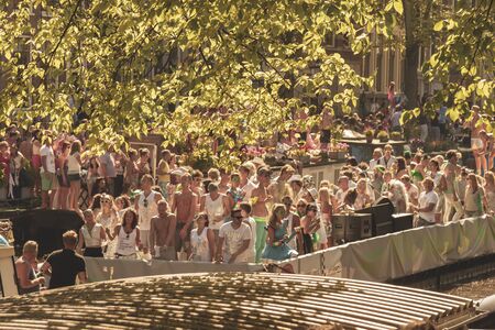Amsterdam, Netherlands - August 3, 2013: A vintage color tone picture  of Amsterdam gay parade in a canal on a sunny day with people having fun dancing on a boatのeditorial素材
