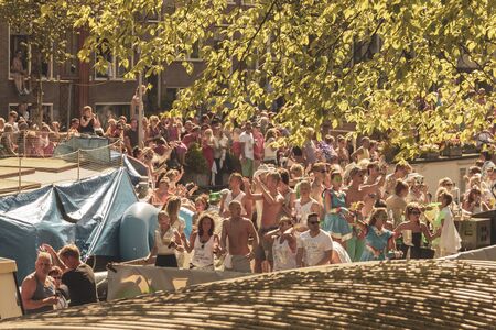 Amsterdam, Netherlands - August 3, 2013: A vintage color tone picture  of Amsterdam gay parade in a canal on a sunny day with people having fun dancing on a boatのeditorial素材