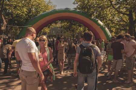 Amsterdam, Netherlands - August 3, 2013: A vintage color tone picture  of Amsterdam gay parade in a canal on a sunny day with people having fun dancing on a boatのeditorial素材