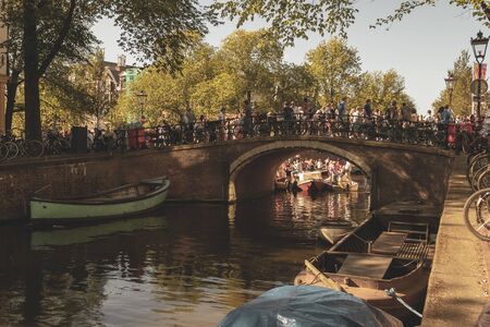 Amsterdam, Netherlands - August 3, 2013: A vintage color tone picture  of Amsterdam gay parade in a canal on a sunny day with people having fun dancing on a boatのeditorial素材