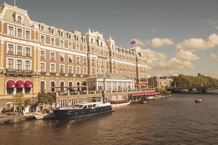 Amsterdam, Netherlands - August 3, 2013: A vintage color tone picture  of Amsterdam gay parade in a canal on a sunny day with people having fun dancing on a boatのeditorial素材