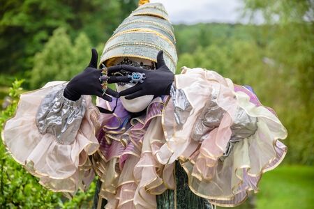 Mysterious man in masquerade mask with hands covering faceの写真素材