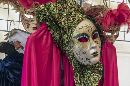 Couple standing in masks and red masquerade costumes during Venetian carnival in Annevoie  gardens, Rue des jardins, 37 a, Annevoie/ Belgiumの写真素材