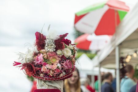 ANNEVOIE GARDENS, BELGIUM - June 9, 2019: Woman in a carnival hat from the back in Venice costume in Annevoie gardens, Belgium.の写真素材