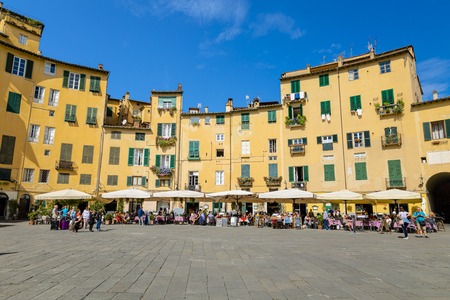 Lucca, Tuscany / Italy - October 10, 2019: View of Piazza dell'Anfiteatro, a famous elliptical square in the historic centre of Lucca, with one of the four arched gateway in a sunny autumn dayのeditorial素材